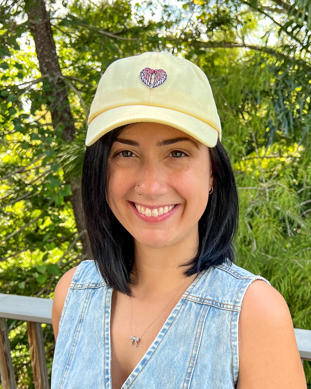 Fantasy cap in light yellow with a patch with angel wings on it.