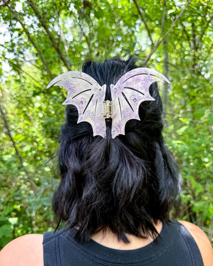 A dual-tone hair clip in pastel purple with purple gem embellishments inspired by the bat boys from A Court of Thorns and Roses by Sarah J. Maas. 
