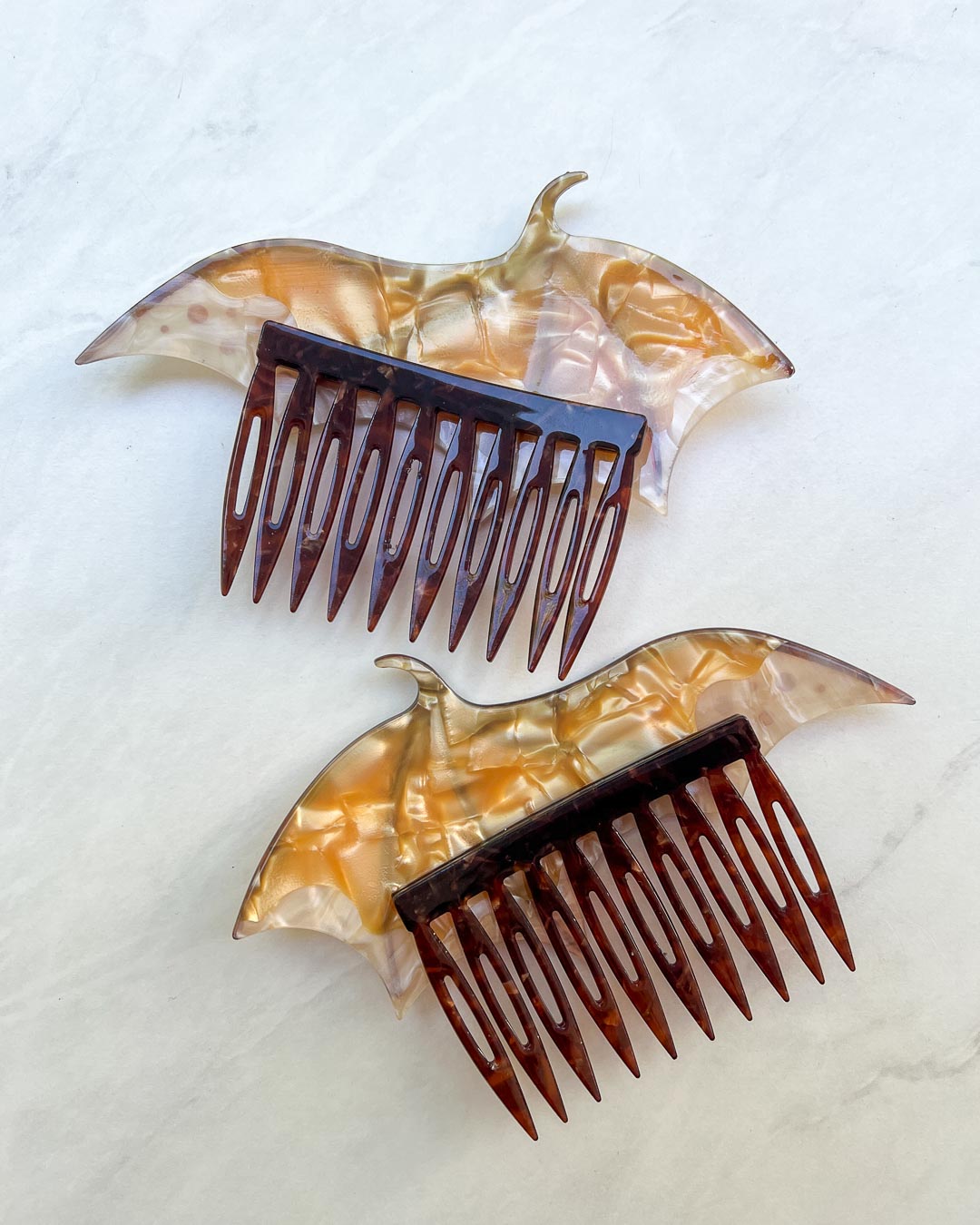 Back of the dragon wing hair accessories featuring a set of gold hair combs and a pearlescent color.