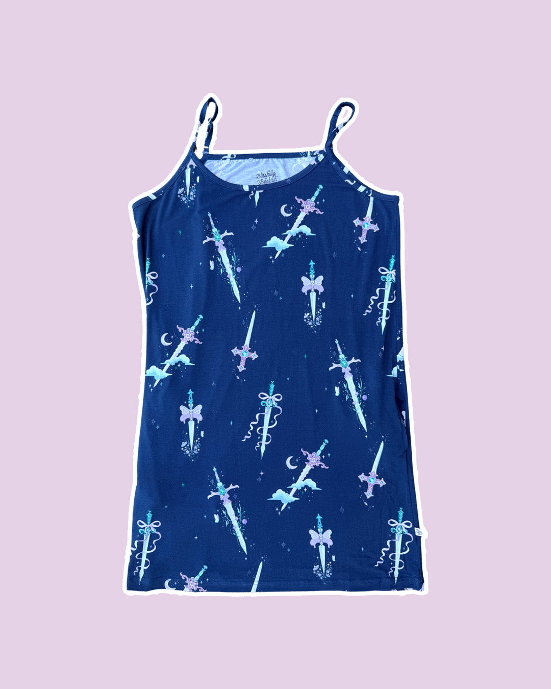 Plain purple background with blue fantasy nightgown with spaghetti straps featuring different whimsical daggers with gems, butterflies, bows, clouds, and crescent moons.