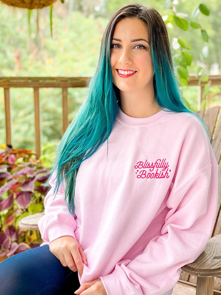 Crew neck sweatshirt with the Blissfully Bookish logo on the left chest in hot pink.