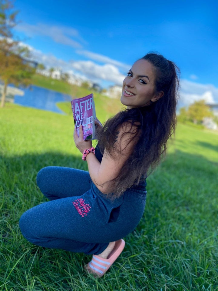 Embroidered sweatpants with the Blissfully Bookish logo written in pink on the left thigh of the joggers.