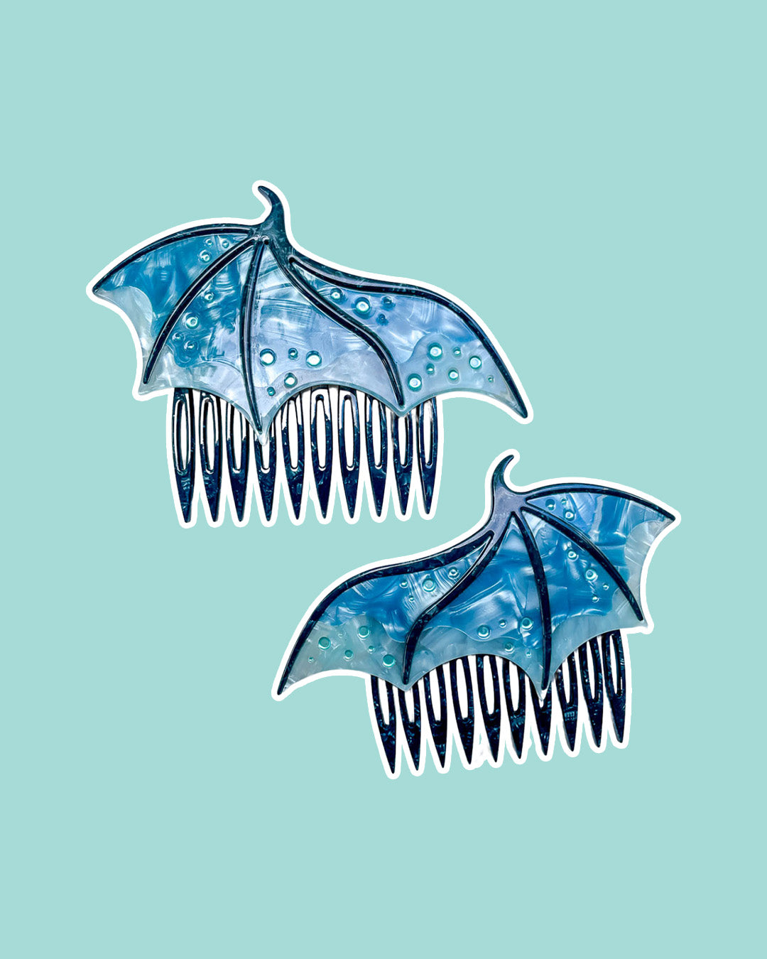 Dragon wing hair combs for fantasy fans in blue featuring engraved embellishments and a pearlescent blue color.