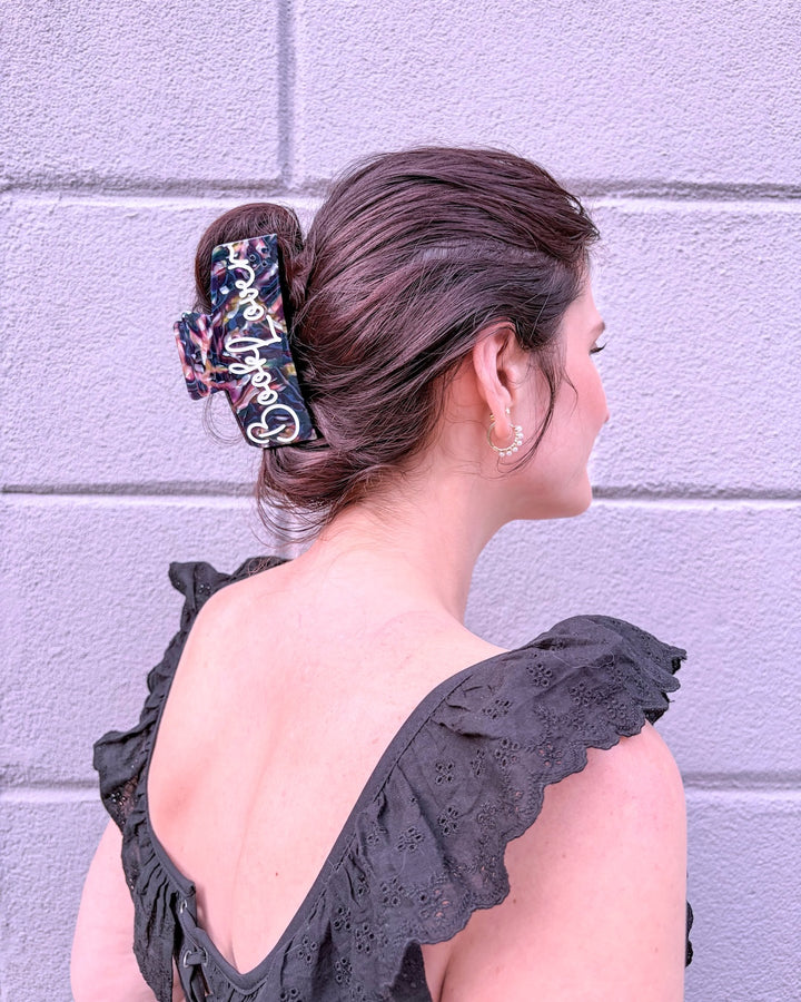 Woman wearing a hair claw clip for readers featuring &