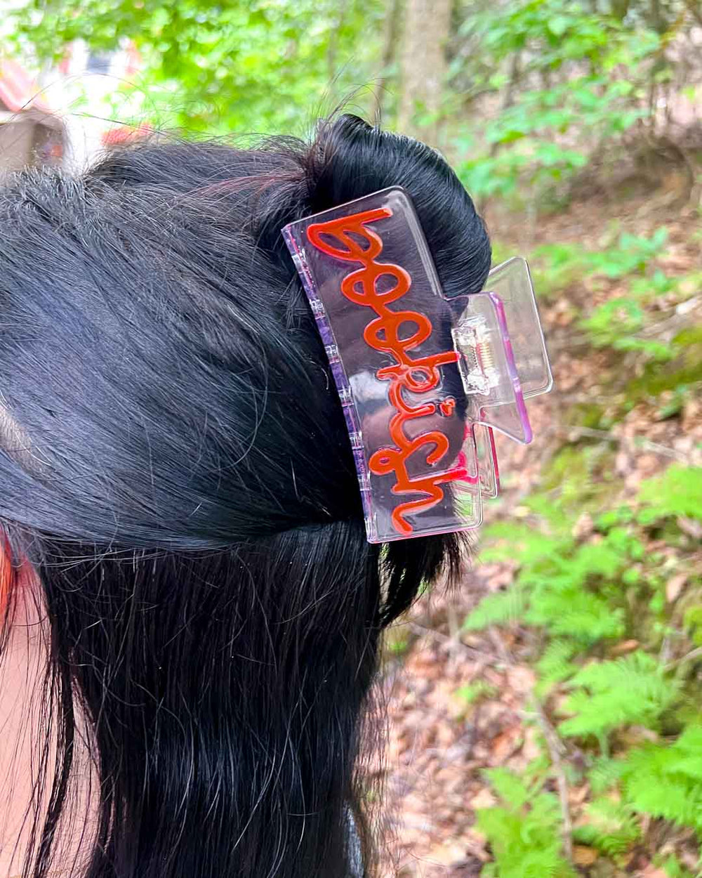 Bookish hair clip in transparent acetate with 'Bookishr' written in pink doodle text.