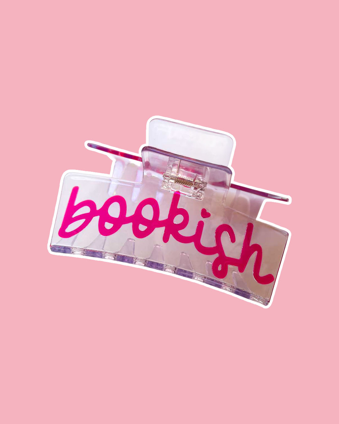 Bookish hair claw clip featuring a transparent double-sided design with 'Bookish' written in pink with a heart as the dot of the i.