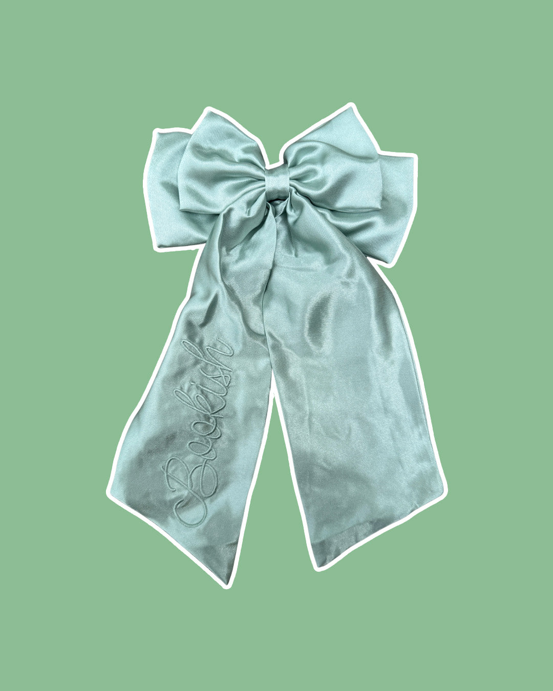 Pale eucalyptus satin hair bow clip embroidered with 'Bookish' in script text on the left tail for book lovers.