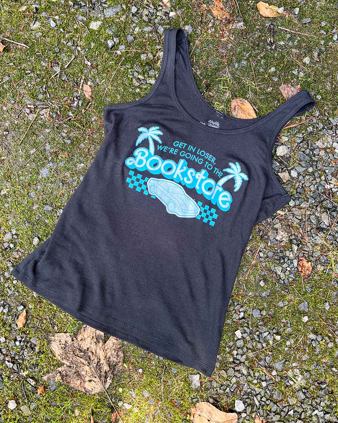 Flat lay of the y2k bookish shirt featuring an illustrated car, a finish line, and palm trees with the line &