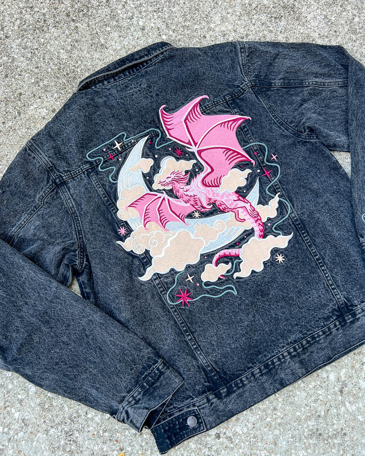 Flat lay of the celestial dragon jacket featuring a flying dragon design with a moon, clouds, and stars on the back for fantasy readers.