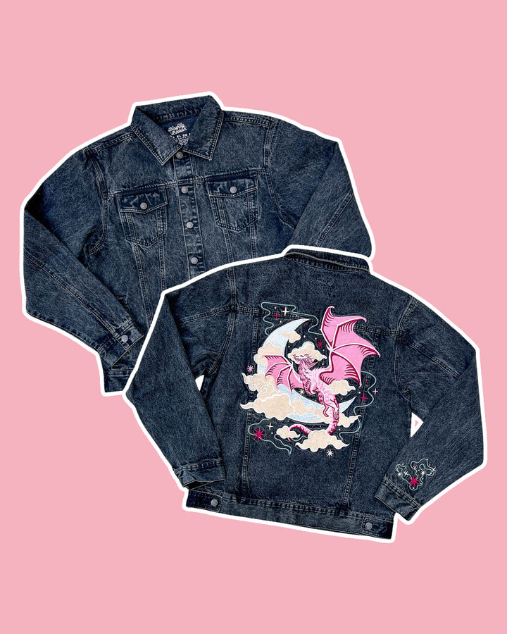 Celestial dragon denim jacket featuring an oversized fit, an embroidered pink dragon, a crescent moon, clouds, stars, and a colorful sleeve detail.
