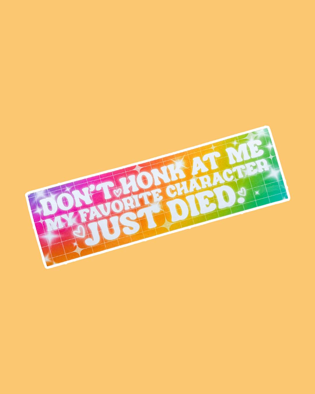 Bookish bumper sticker on a vibrant rainbow background with the quote 'Don't honk at me my favorite character just died.'
