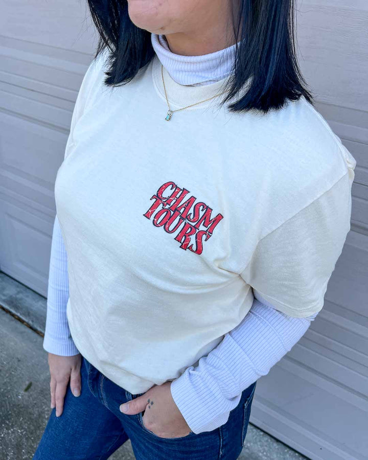 Close up of the Chasm Tours shirt featuring "Chasm Tours" written in all caps and red, distressed text on the top left chest.