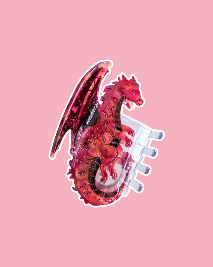 Red dragon hair claw clip for fantasy readers with an iridescent shine on a purple background.