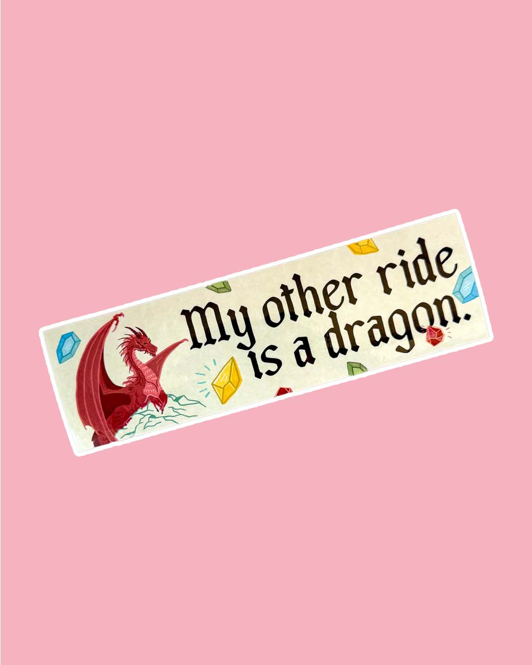 Bookish bumper sticker for fantasy fans featuring a red dragon perched on a mountain, multi-colored gems, and the phrase, 'My other ride is a dragon.'