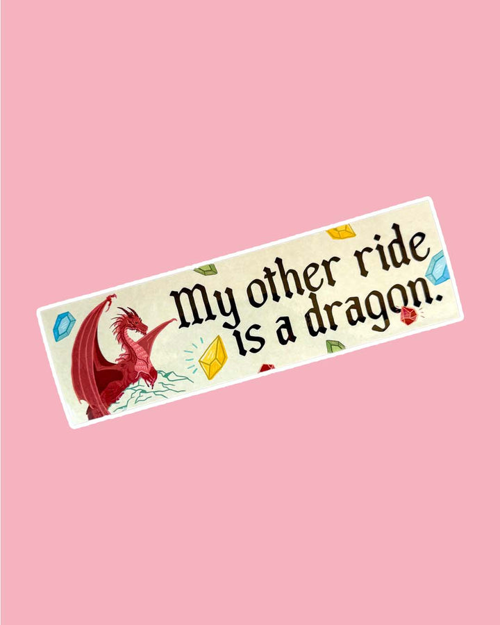 Bookish bumper sticker for fantasy fans featuring a red dragon perched on a mountain, multi-colored gems, and the phrase, &