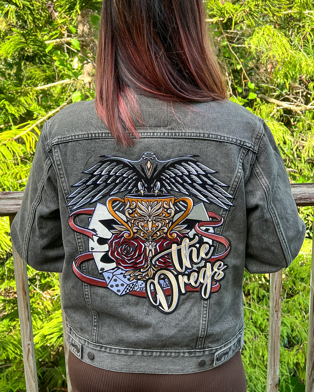 The Dregs patch for Six of Crows fans featuring a detailed design of a crow, a chalice, playing cards, ribbon, dice, and roses.