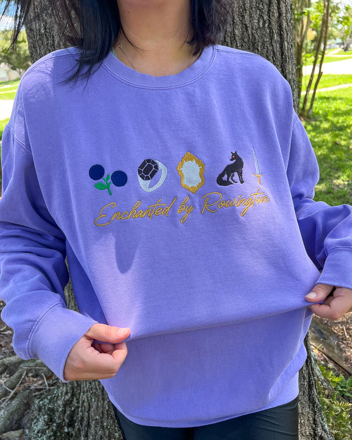 Person wearing a purple embroidered sweatshirt for Phantasma and Enchantra fans with the phrase &