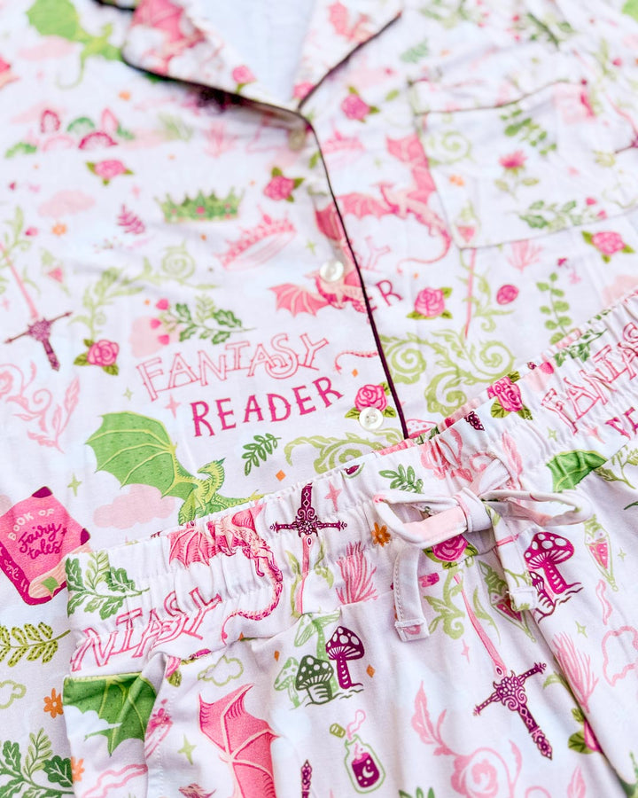 Close up of the fantasy reader pajamas set featuring dragons, a book of fairy tales, potions, mushrooms, swords, and more.