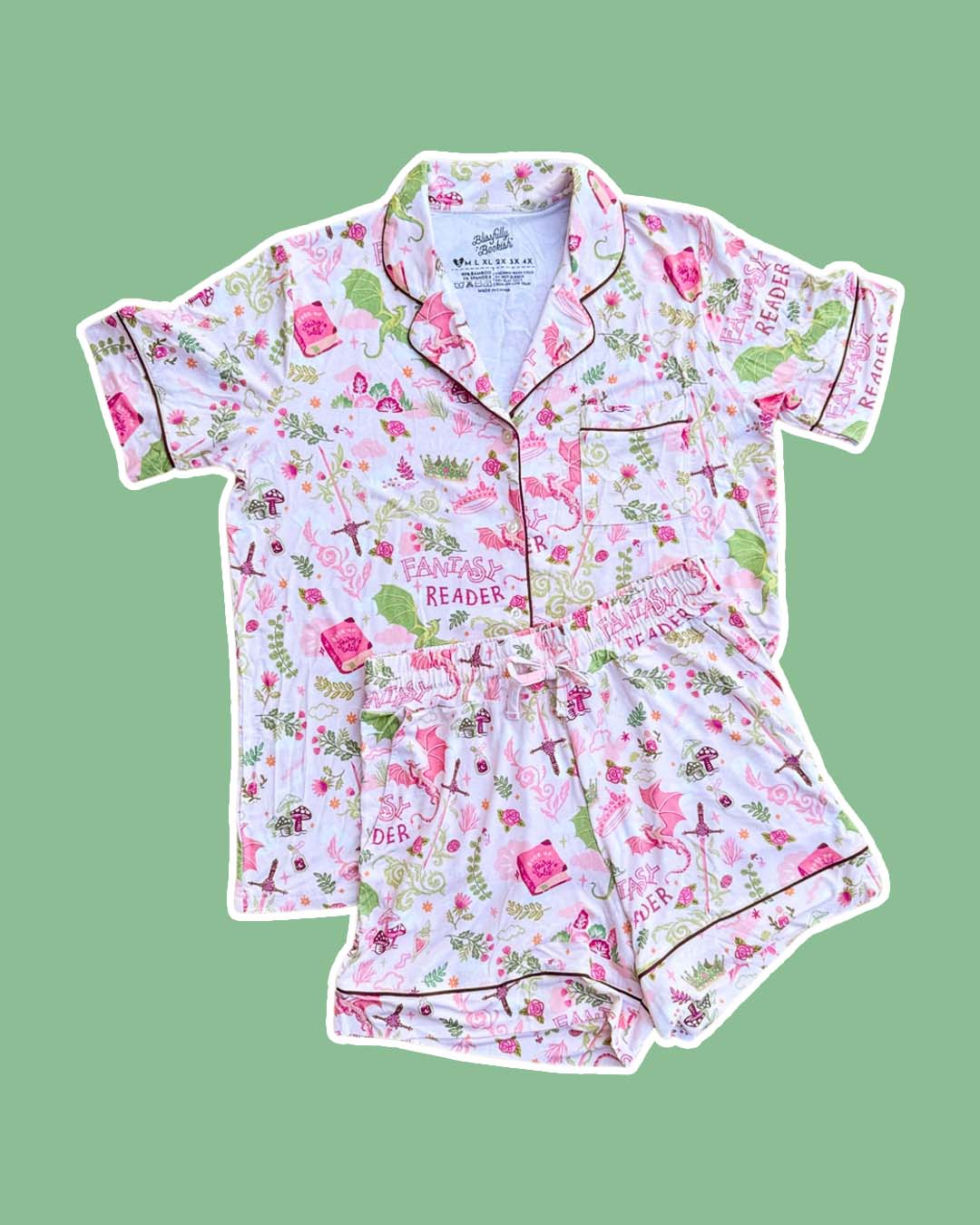 Fantasy reader pjs set with collared button down shirt, a pocket, and a stretchy waistband with a printed design featuring dragons, swords, crowns, books and more.