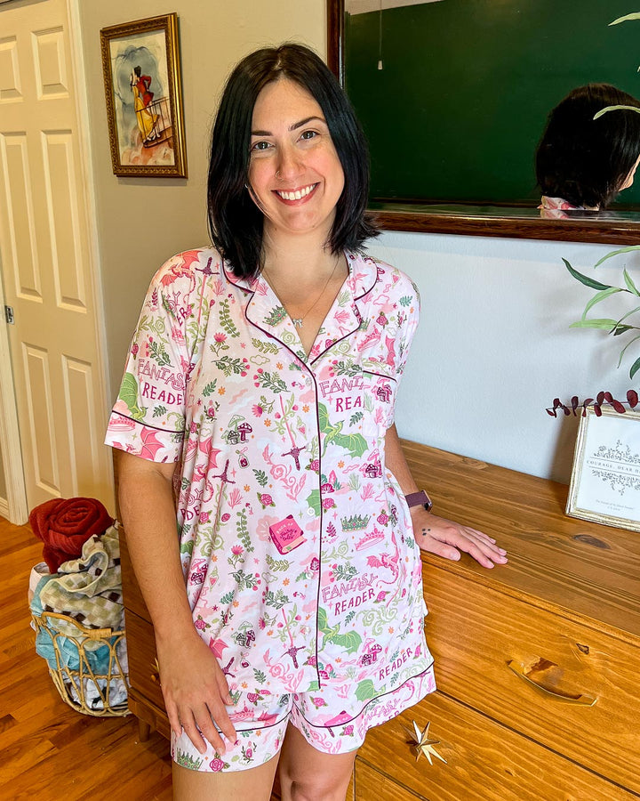 Fantasy pajamas for book lovers with illustrated designs of swords, dragons, mushrooms, flowers, and crowns.