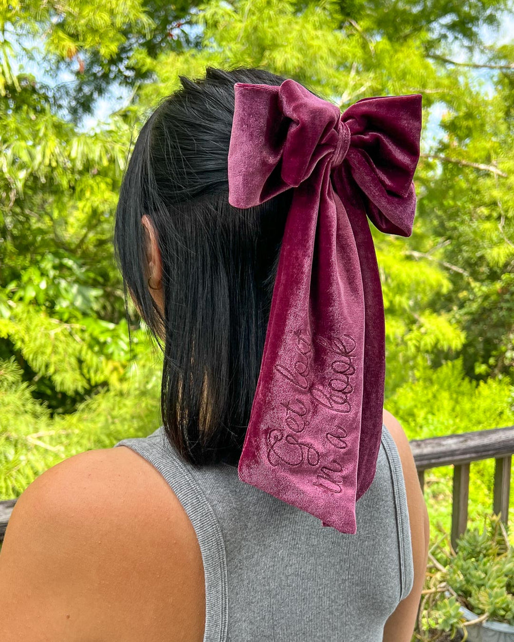 Bookish hair accessory with plum velvet and the phrase 'Get lost in a book' embroidered on the hair bow.