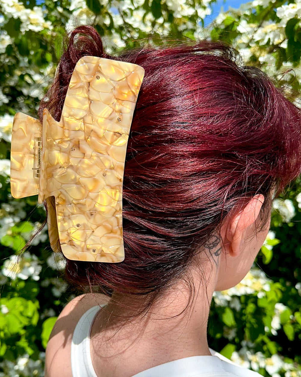 A dual-tone gold bookish hair clip for fantasy lovers featuring subtle dragon scales with pearlescent designs and topaz gems.