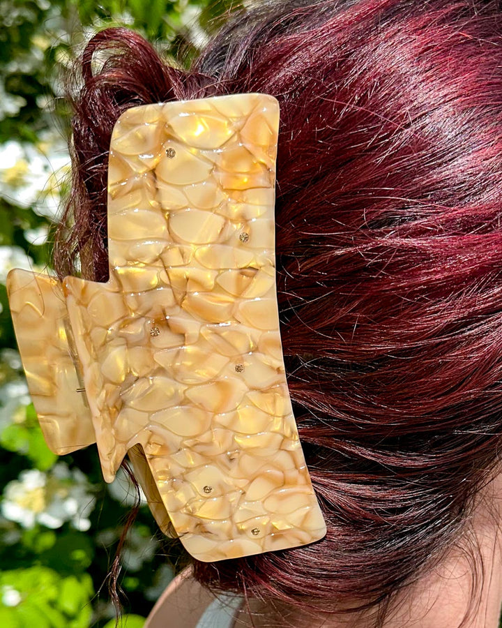 Dragon scale hair accessory with gold pearlescent swirls and topaz gems for fantasy readers.