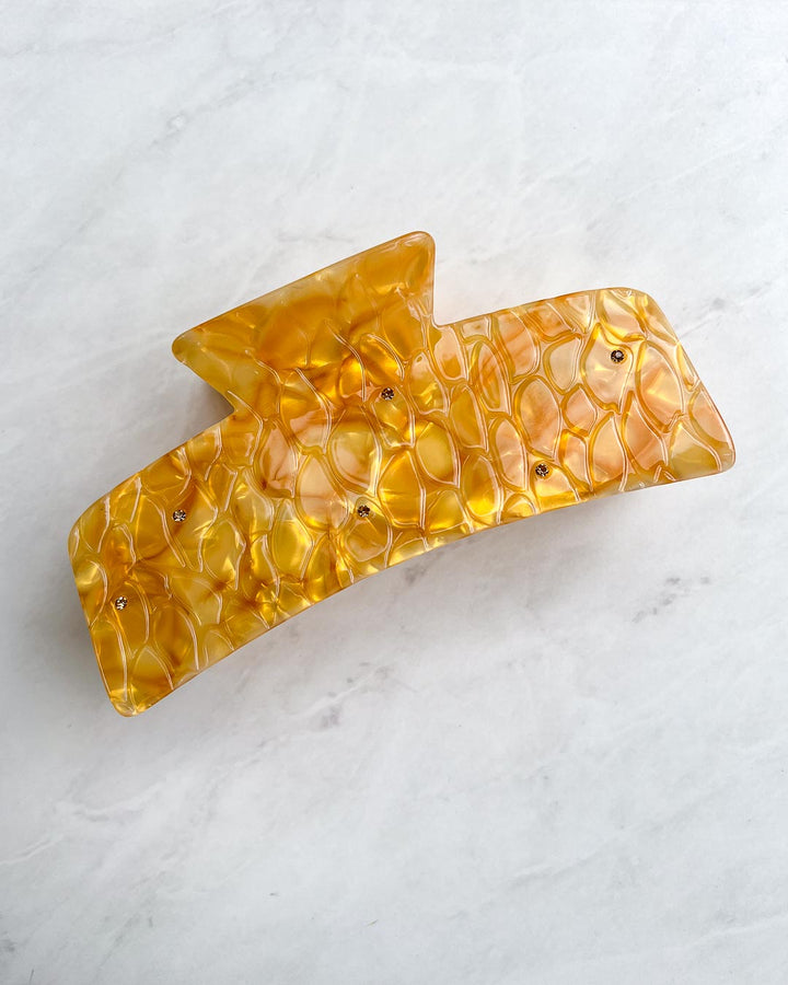 Large dragon scale hair claw clip for fantasy lovers with gem embellishments and a gold pearlescent swirl design.