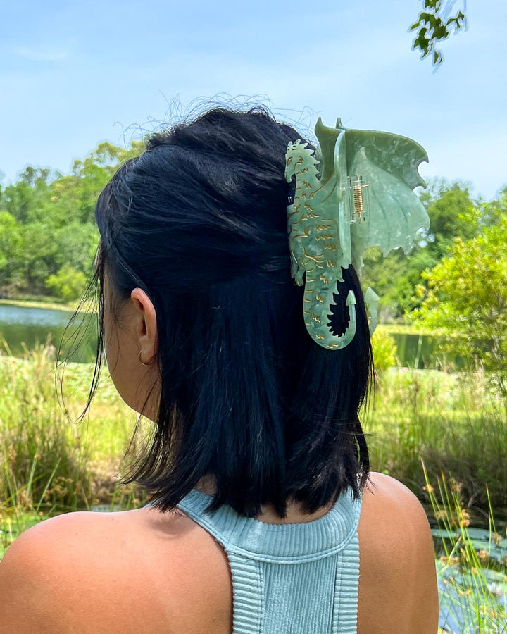 A green and gold detailed bookish hair clip for fantasy lovers in the shape of a dragon.