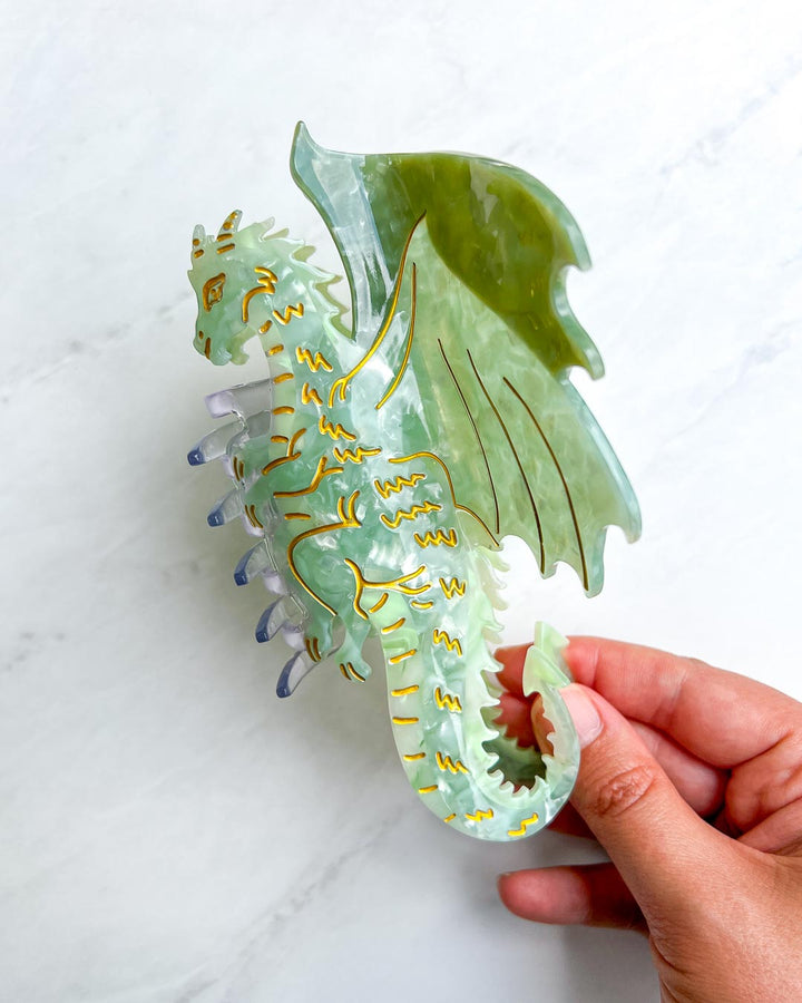 Hair accessory gift for fantasy lovers in the shape of a dragon with green and gold details on the claw clip.