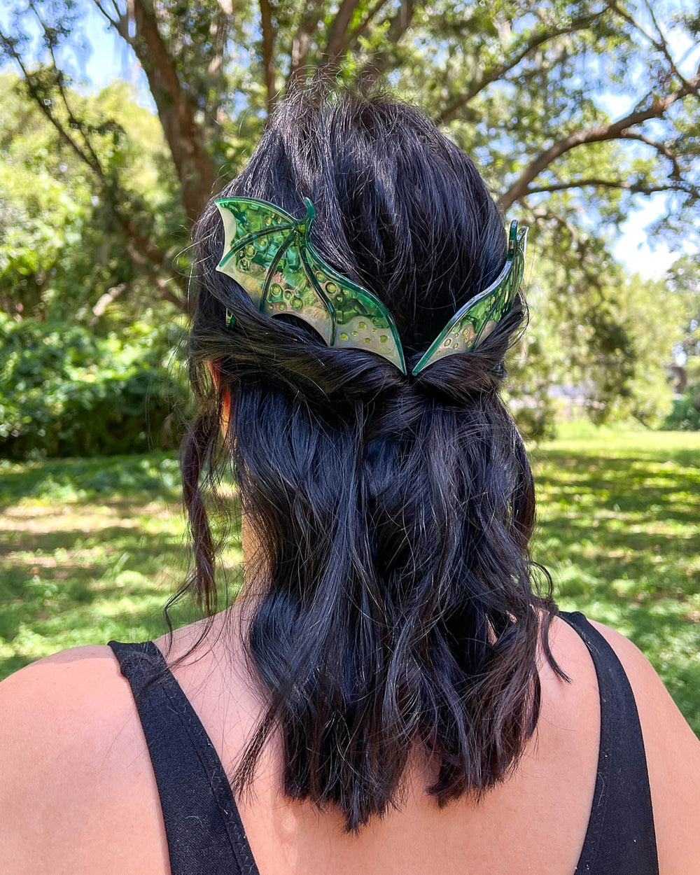 Dragon hair combs with engraved embellishments and a green-toned pearlescent acetate material. 