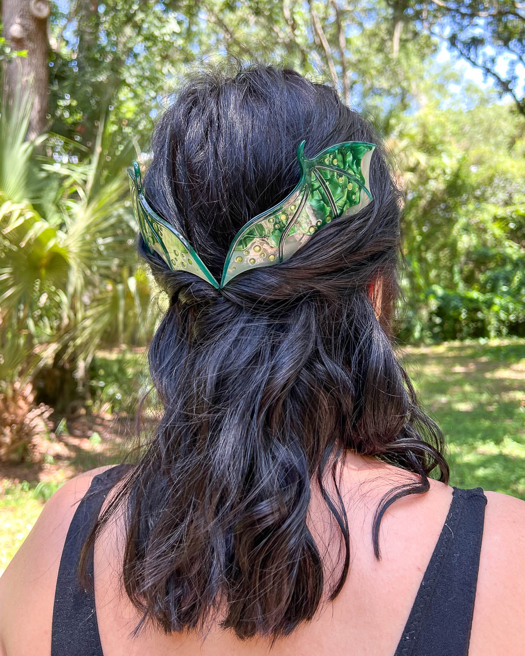 Hair combs for dragon lovers featuring two large combs in the shape of dragon wings with engraved details and a pearlescent green color.