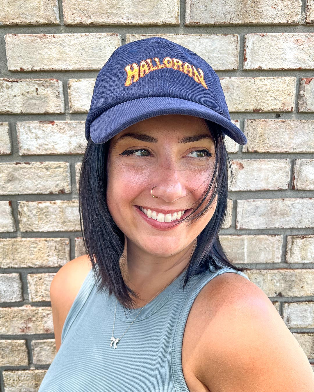 Navy blue Kate Golden cap featuring a yellow logo for Halloran from If Not For My Baby.