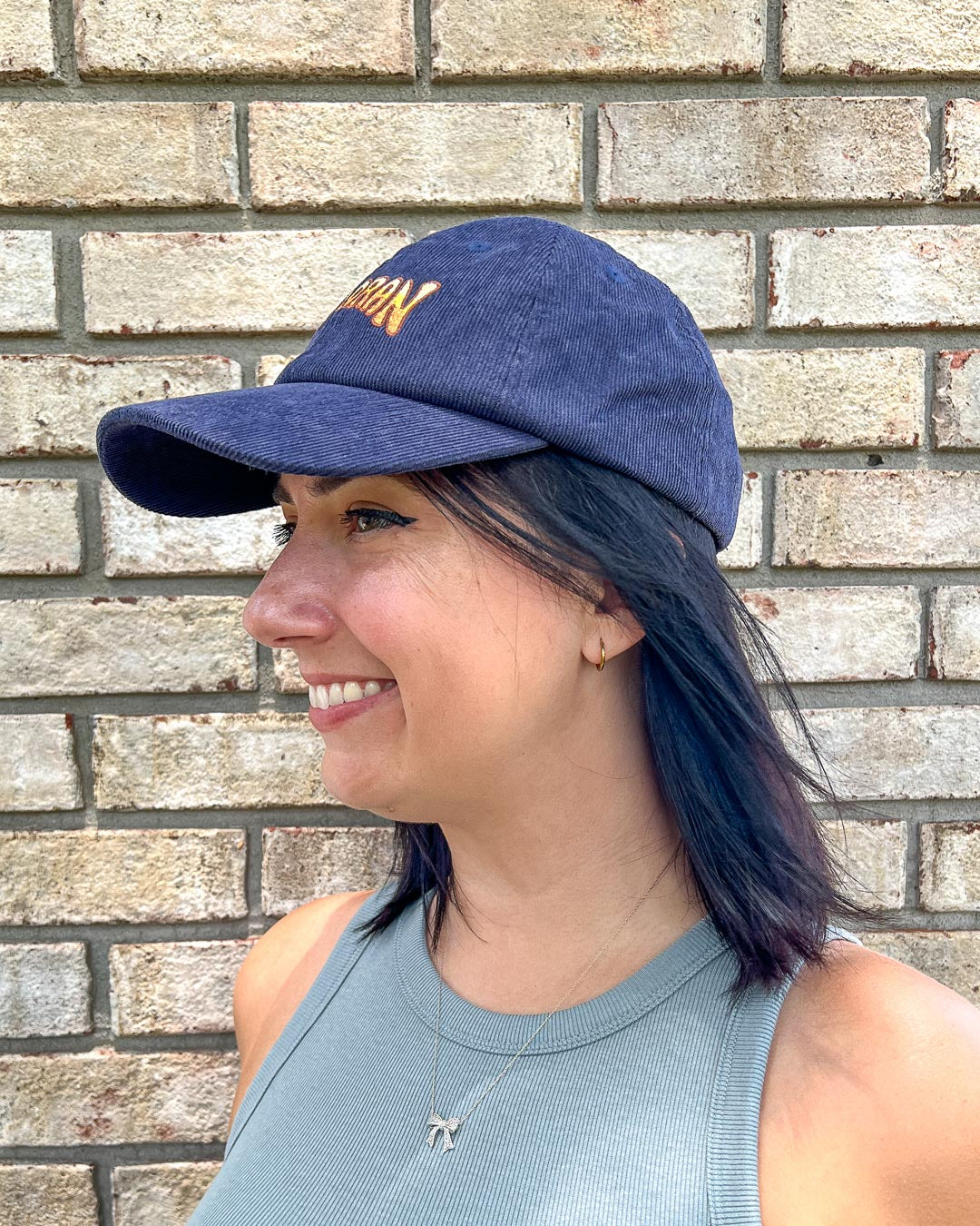 Woman wearing a navy blue hat for If Not For My Baby fans featuring a logo for Halloran.