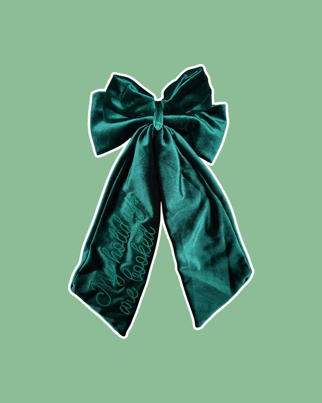 Green velvet hair bow clip embroidered with script text reading 'My holidays are booked' for book lovers.