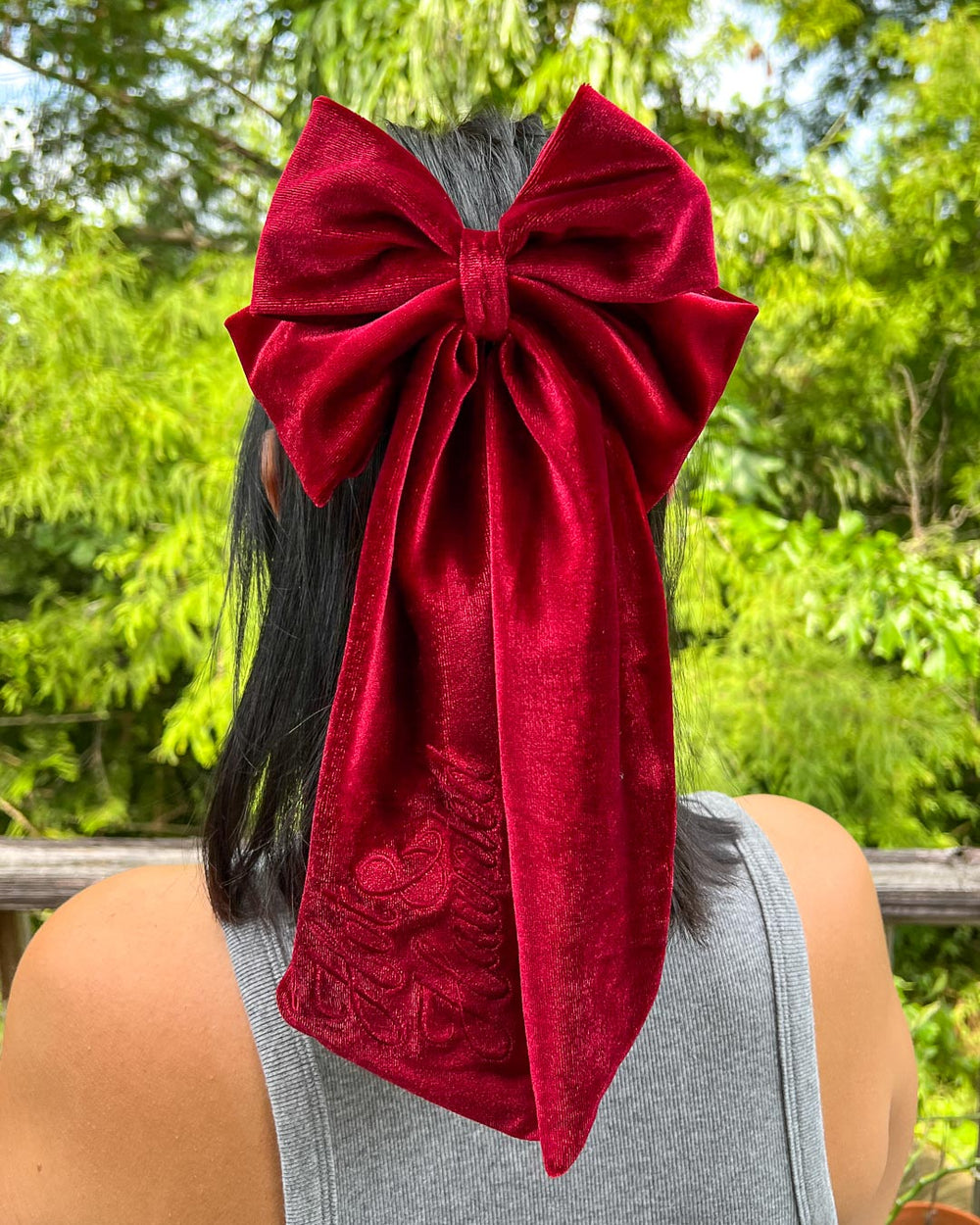 Bookish hair accessory with red velvet material and the phrase 'Hot & Haunted' embroidered on the hair bow.