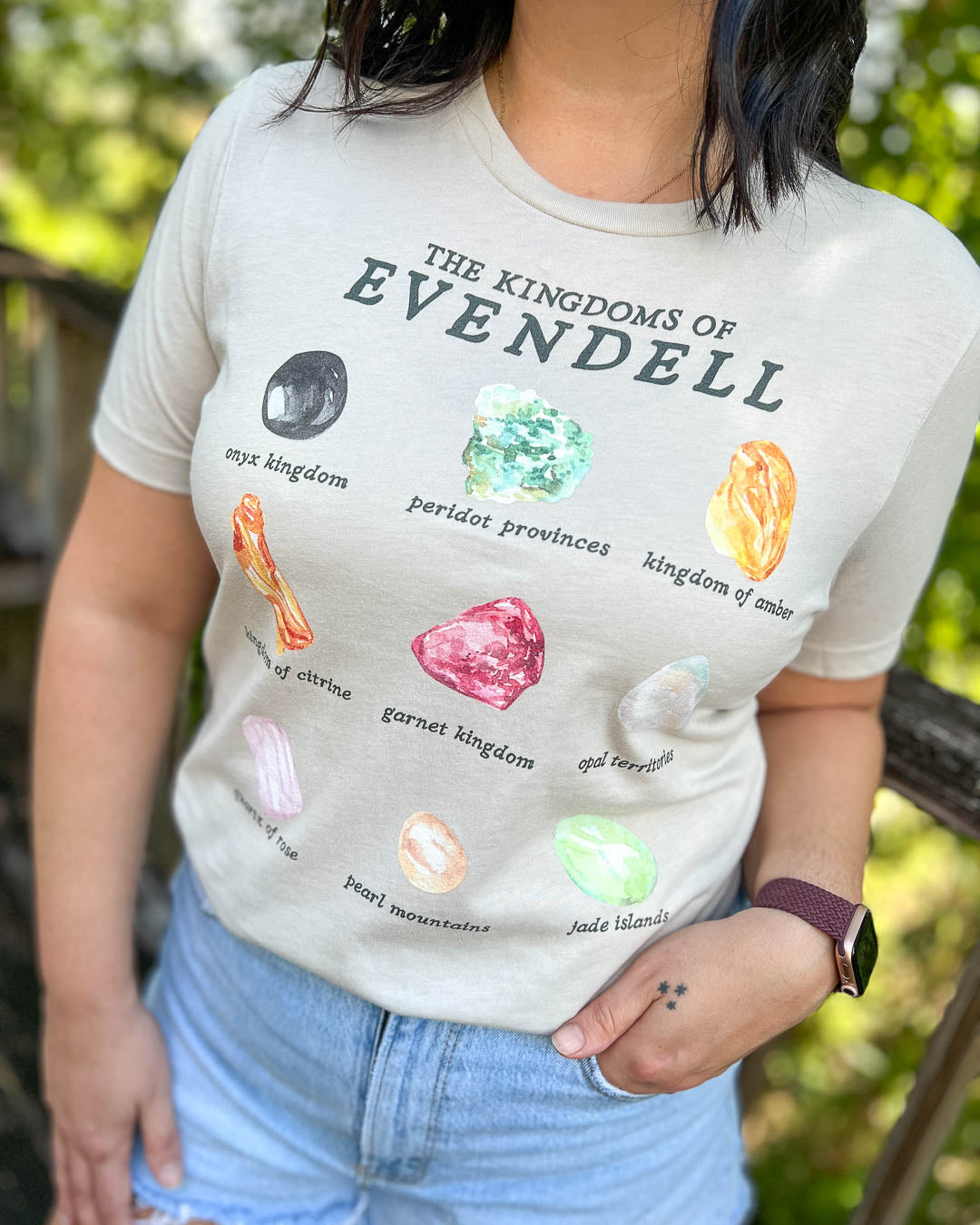 Kate Golden shirt for A Dawn of Onyx fans featuring a design for all the Kingdoms of Evendell and their associated gems, including onyx, peridot, amber, citrine, garnet, opal, quartz, pearl, and jade.