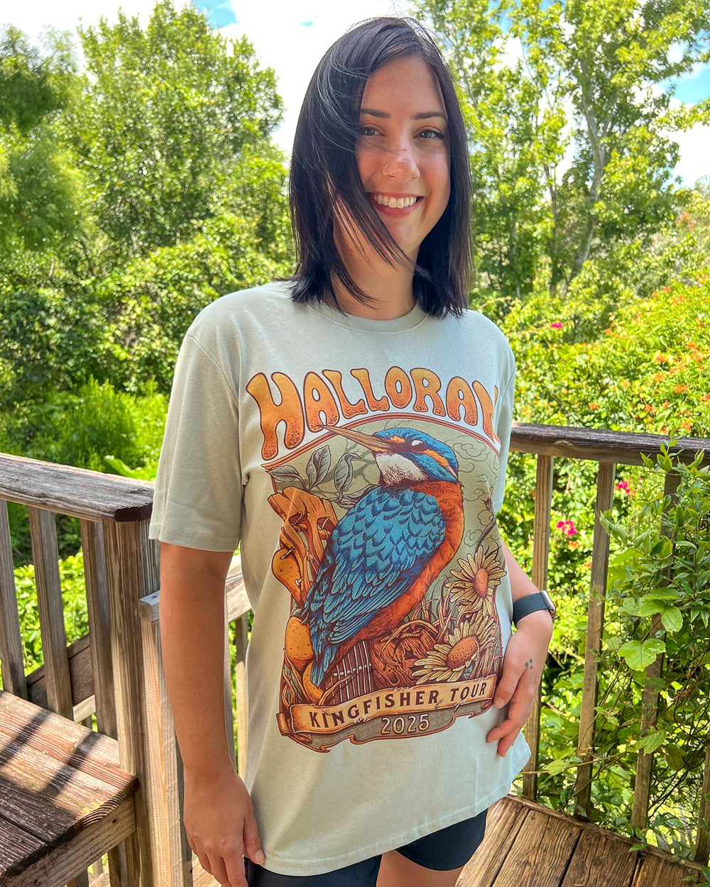 Front of the Kate Golden shirt for If Not For My Baby fans featuring a poster design for the Kingfisher Tour with a kingfisher perched on a guitar and daisies around it on a light green tee.