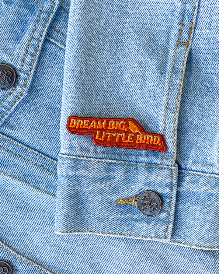 Daisy Jones patch in orange and maroon with the quote &