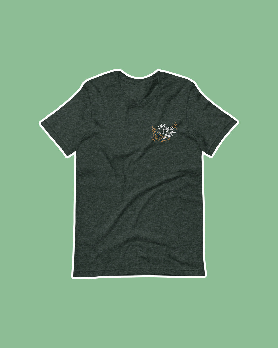 Wild is the Witch shirt featuring an embroidered design in white and gold with the quote 'Magic is a gift' on a feather on the left chest of a green shirt.