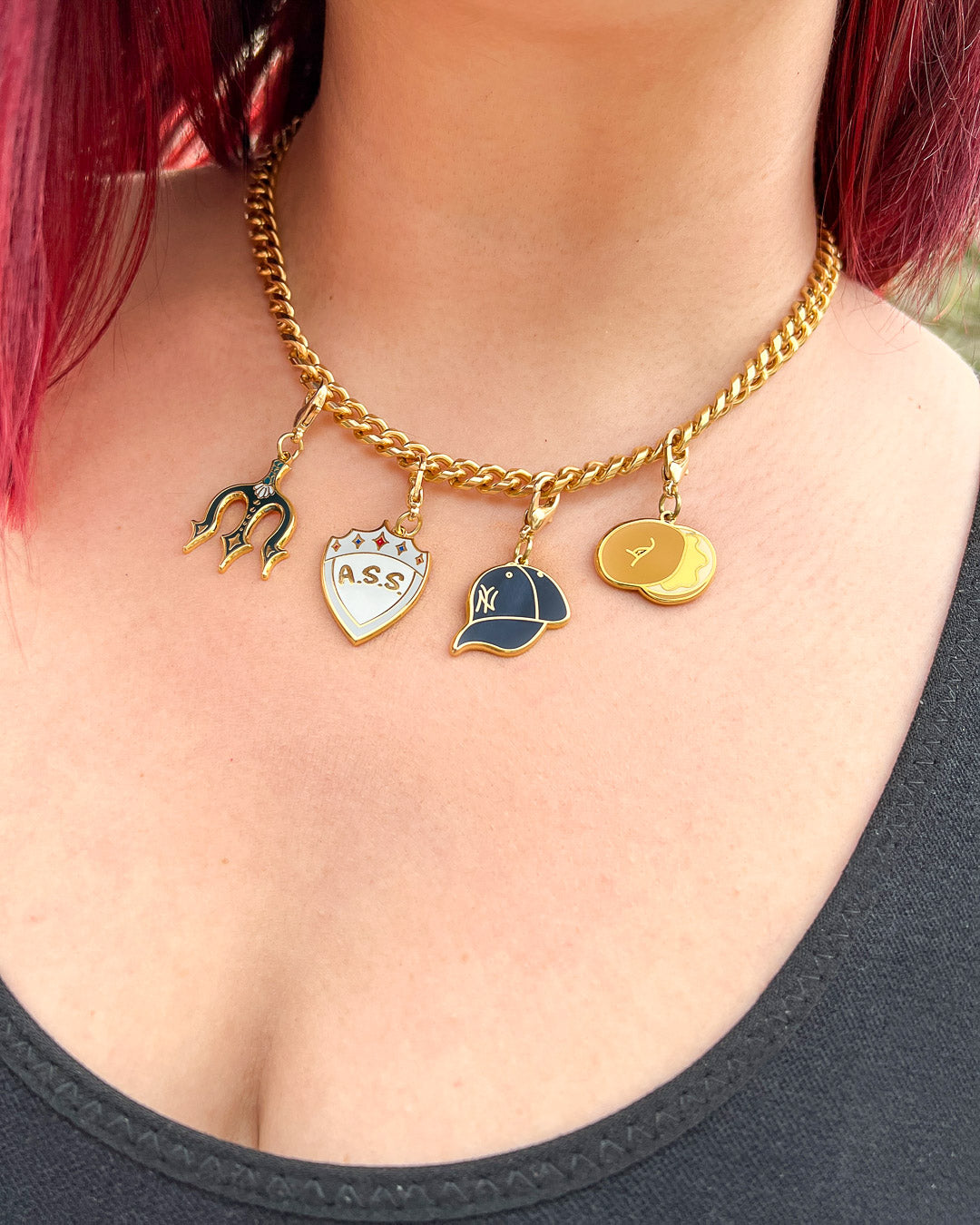 Bookish charm sets featuring the Zodiac Academy charms with the A.S.S. shield and bagel and the Percy Jackson charms with a Yankees baseball cap and a trident.