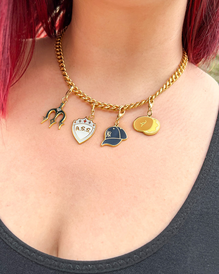 Bookish charm sets featuring the Zodiac Academy charms with the A.S.S. shield and bagel and the Percy Jackson charms with a Yankees baseball cap and a trident.