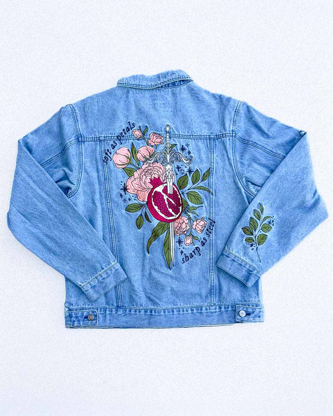 Embroidered jacket for fantasy fans featuring a whimsical Persephone design with a pomegranate, a sword, flowers, leaves, stars, and the quote &