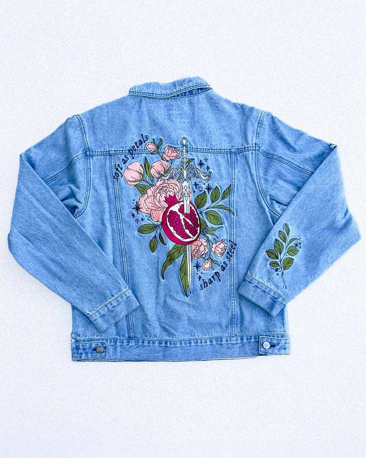 Embroidered jacket for fantasy fans featuring a whimsical Persephone design with a pomegranate, a sword, flowers, leaves, stars, and the quote &