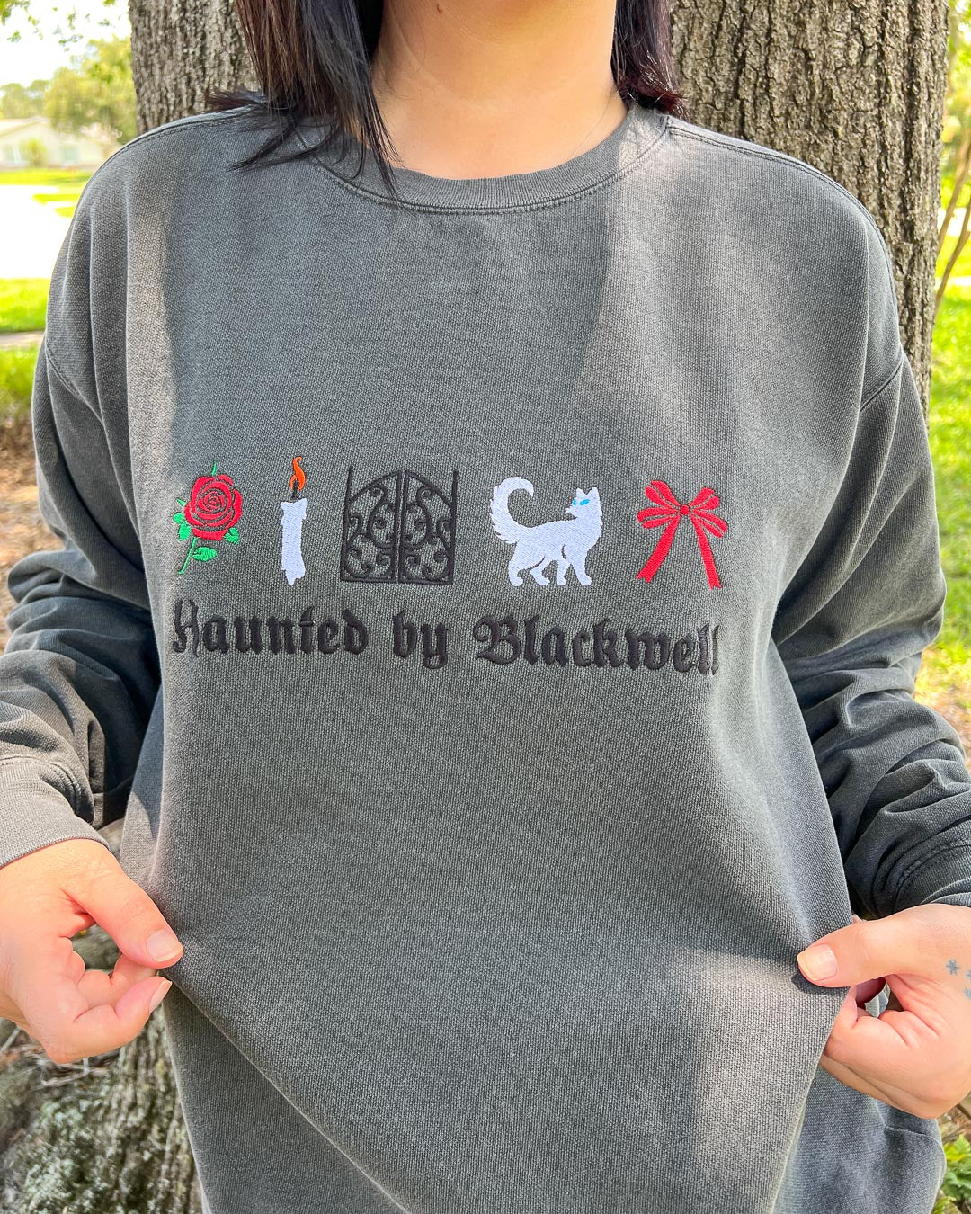 Person wearing an embroidered sweatshirt for Phantasma fans featuring &