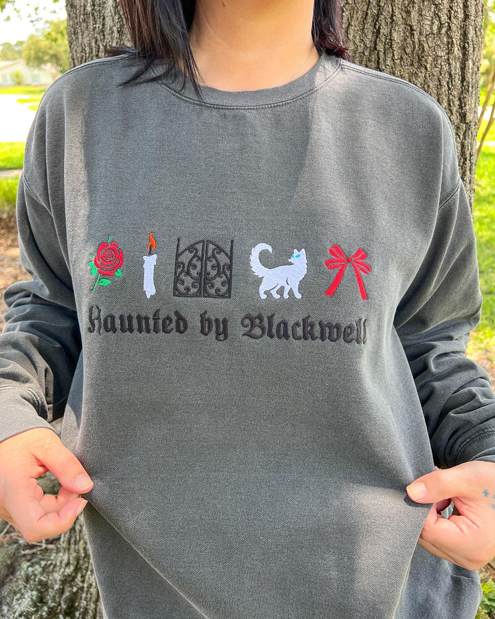 Person wearing an embroidered sweatshirt for Phantasma fans featuring &