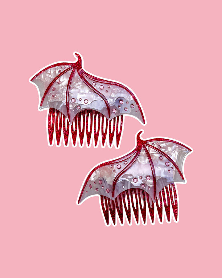 Dragon wing hair combs for fantasy fans in pink featuring engraved embellishments and a pearlescent pink color.
