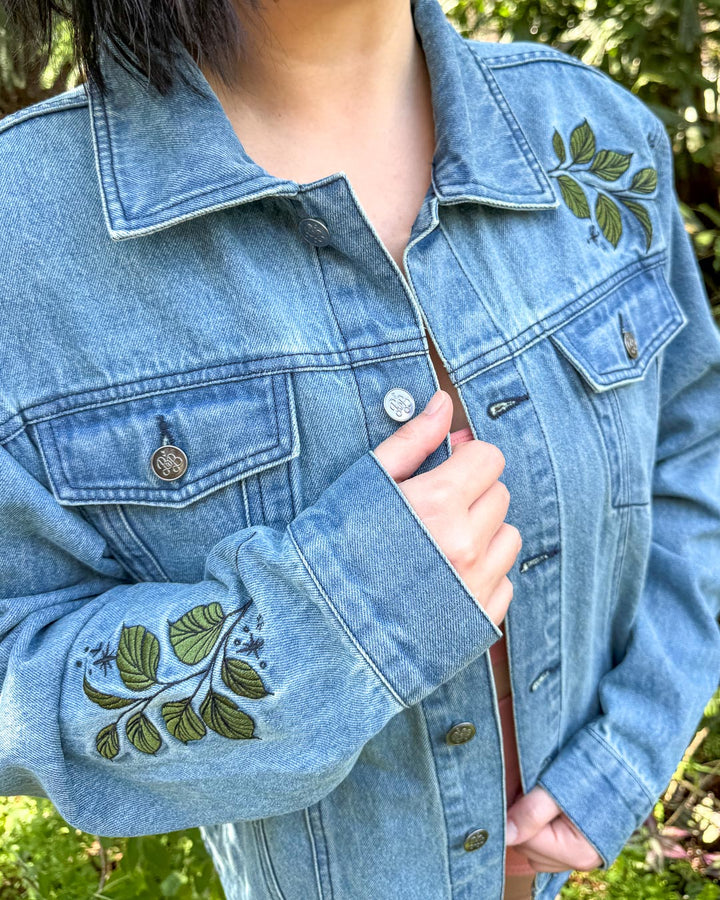 Bookish jean jacket featuring the embroidered leaves on the sleeve and shoulder.