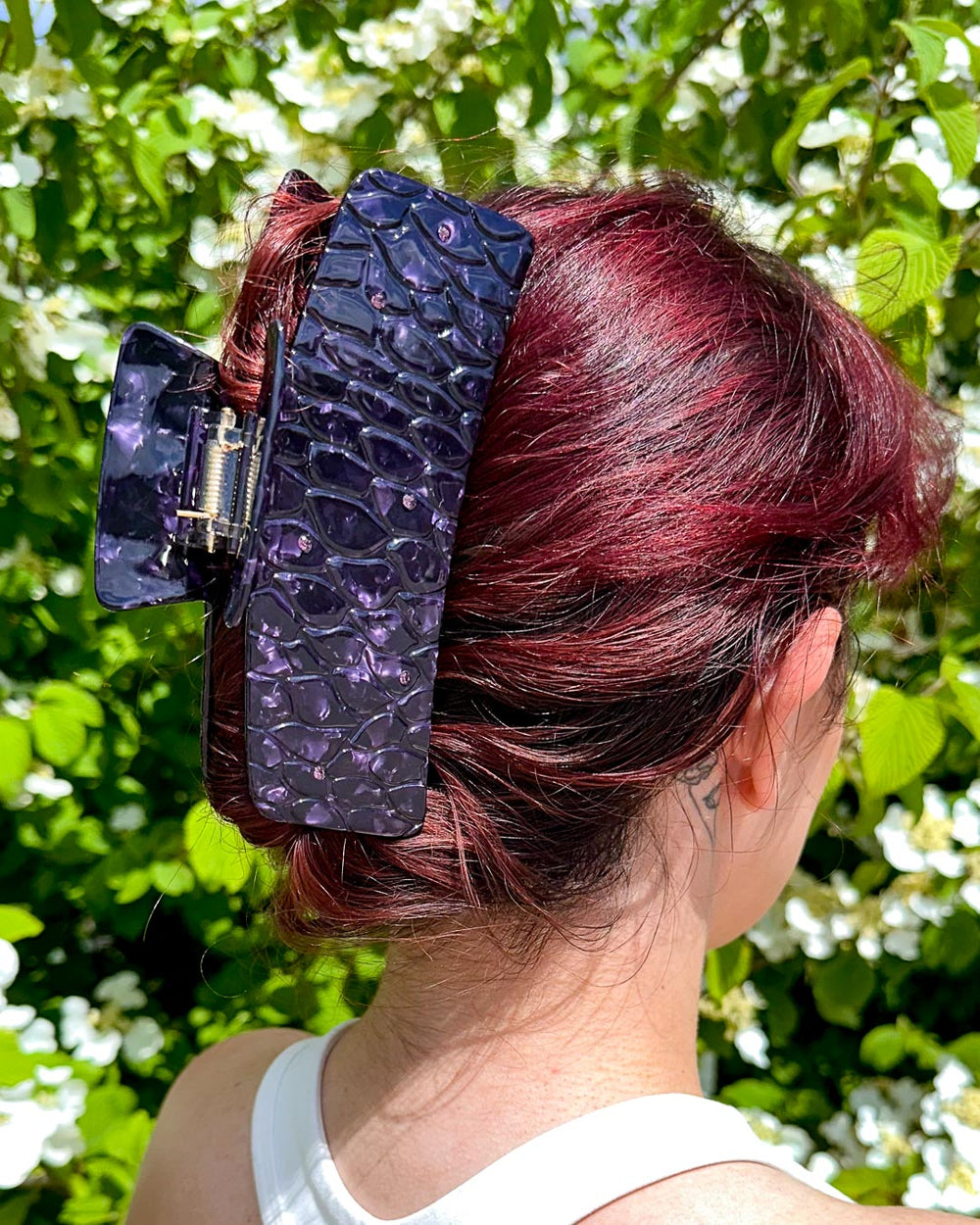 A dual-tone purple bookish hair clip for fantasy lovers featuring subtle dragon scales with pearlescent designs and dark purple gems.