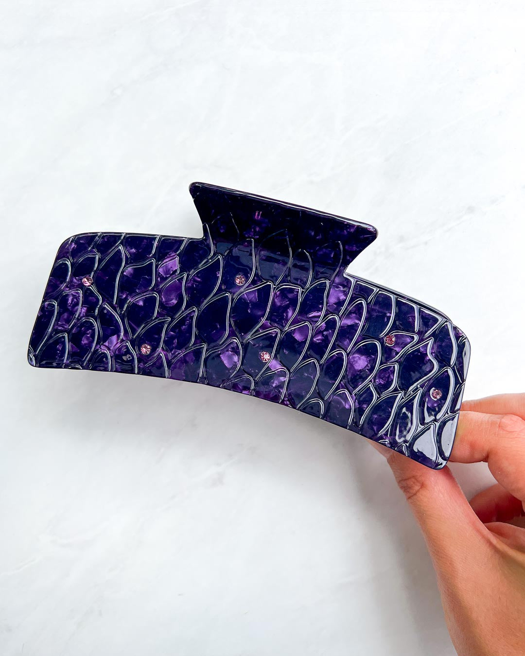 Large dragon scale hair claw clip for fantasy lovers with gem embellishments and a purple pearlescent swirl design.